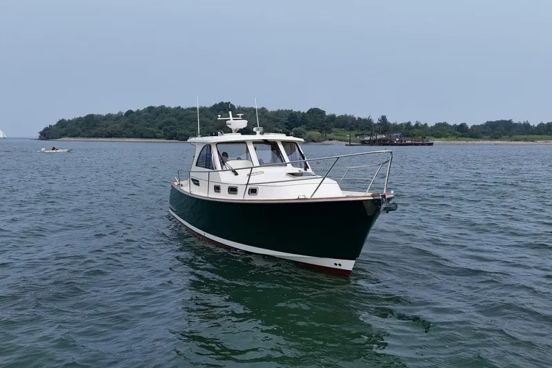 Slide: The Image of 2008 Legacy Yachts 32 cruising on calm waters near a lush island. - 5