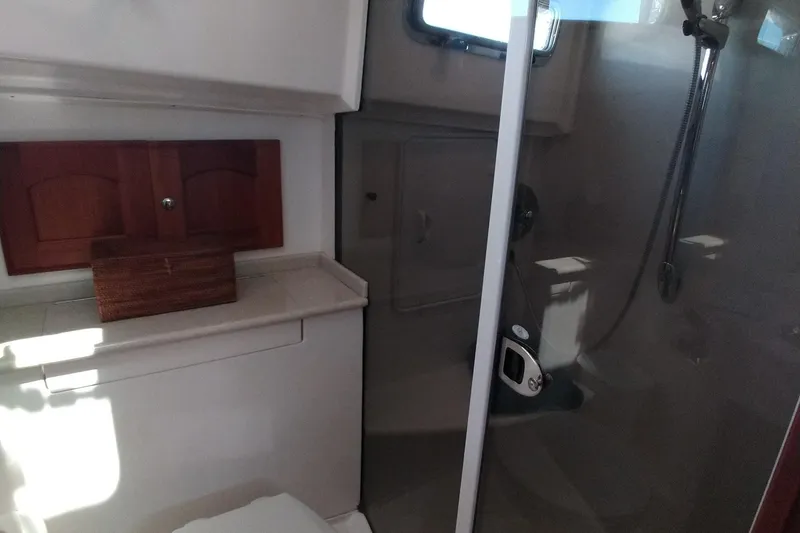 Slide: The Image of Bathroom interior of 2008 Legacy Yachts 32, featuring shower and wooden cabinet. - 54