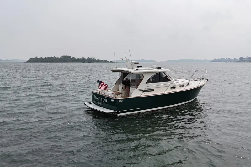 Slide: The Image of 2008 Legacy Yachts 32 cruising on calm waters with American flag. - 6