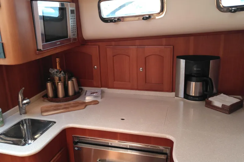 Slide: The Image of Galley kitchen in 2008 Legacy Yachts 32, featuring microwave, sink, and coffee maker. - 60