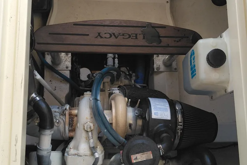 Slide: The Image of Engine compartment of a 2008 Legacy Yachts 32, showcasing mechanical components and fluid reservoir. - 64