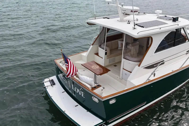 Slide: The Image of 2008 Legacy Yachts 32 on water, featuring American flag and elegant deck design. - 7