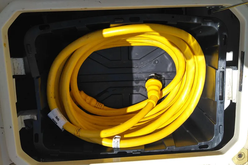 Slide: The Image of Coiled yellow hose in storage compartment of 2008 Legacy Yachts 32. - 80