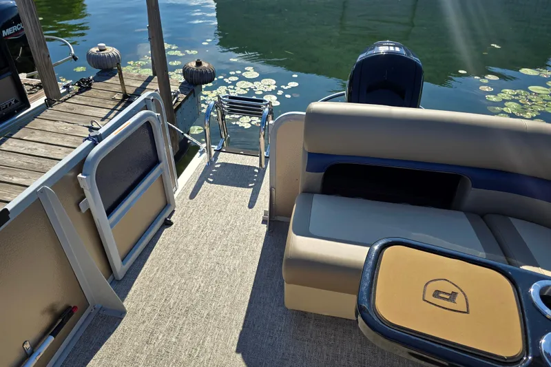 Slide: The Image of 2025 Premier 210 SunSation RE pontoon boat interior with seating and water view. - 11