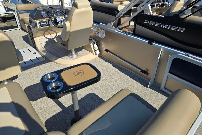 Slide: The Image of Interior of 2025 Premier 210 SunSation RE pontoon boat with beige seating and steering console. - 3