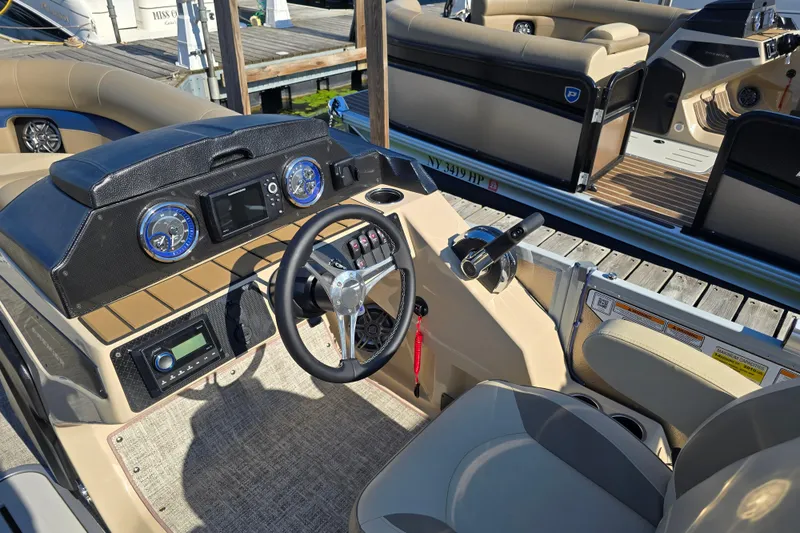Slide: The Image of 2025 Premier 210 SunSation RE boat dashboard with steering wheel and controls. - 4