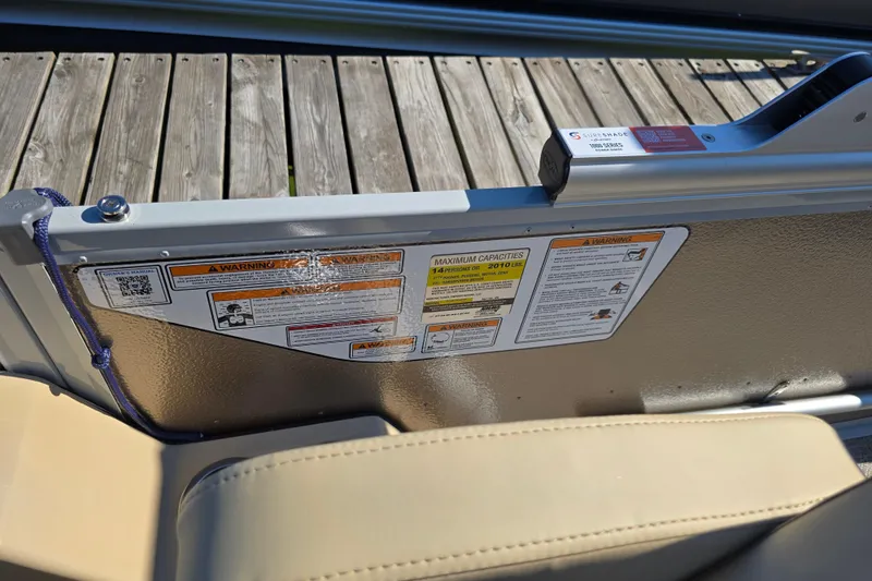 Slide: The Image of 2025 Premier 210 SunSation RE boat safety labels and capacity warnings on deck. - 5