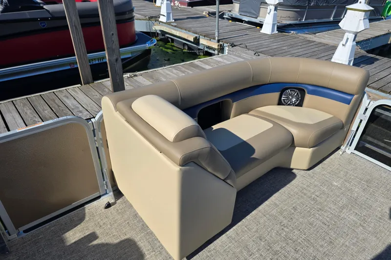 Slide: The Image of Premier 210 SunSation RE 2025 boat interior with beige seating at dock. - 7