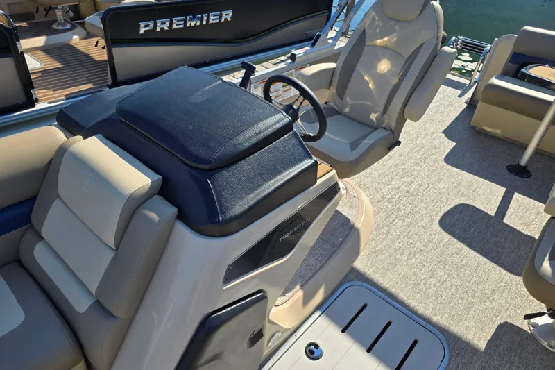 Slide: The Image of Interior of 2025 Premier 210 SunSation RE pontoon boat with luxurious seating and steering console. - 9