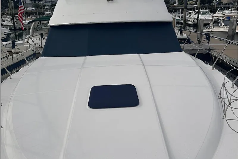 Slide: The Image of 2005 Silverton 42 Convertible yacht deck with blue cover, docked at marina. - 12