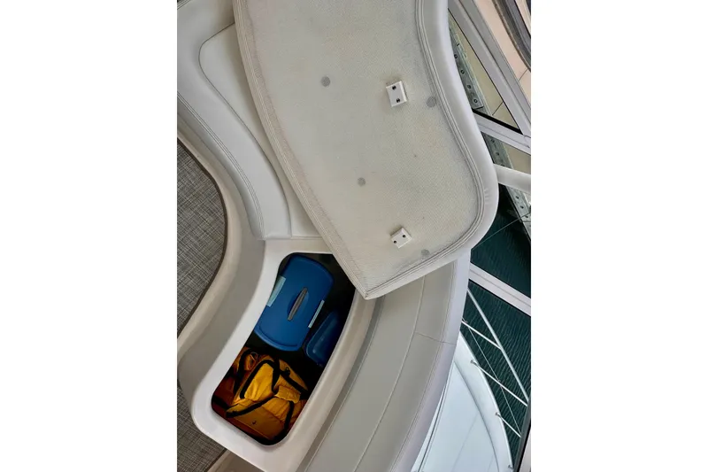 Slide: The Image of Storage compartment on a 2005 Silverton 42 Convertible boat, containing bags and containers. - 16