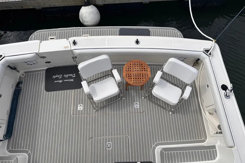 Slide: The Image of 2005 Silverton 42 Convertible yacht deck with chairs and table, docked by water. - 18