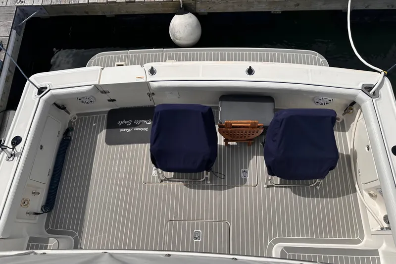Slide: The Image of 2005 Silverton 42 Convertible boat deck with covered chairs and dock view. - 19