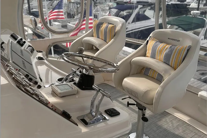 Slide: The Image of 2005 Silverton 42 Convertible yacht helm with plush seating and striped cushions. - 20
