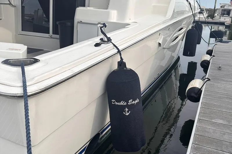 Slide: The Image of 2005 Silverton 42 Convertible yacht docked with fenders, named "Double Eagle." - 23