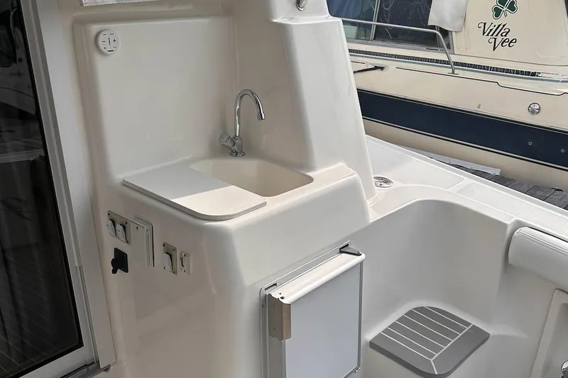 Slide: The Image of 2005 Silverton 42 Convertible yacht sink area with faucet and storage compartment. - 27