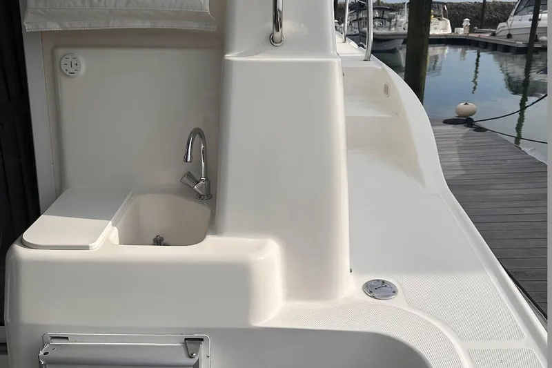 Slide: The Image of 2005 Silverton 42 Convertible yacht deck with sink and faucet, docked at marina. - 30