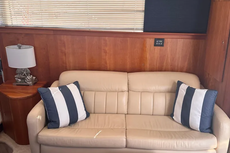 Slide: The Image of Luxurious interior of 2005 Silverton 42 Convertible yacht with beige sofa and striped cushions. - 37