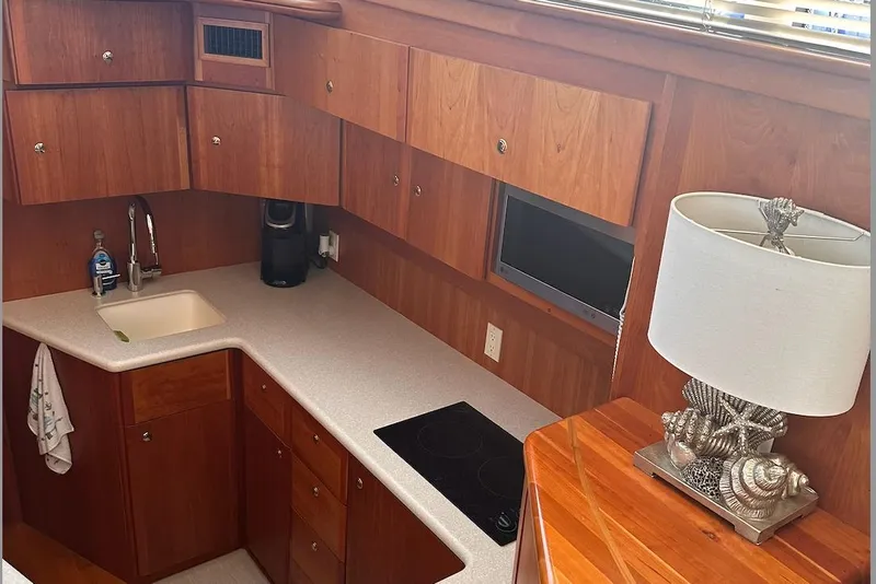 Slide: The Image of 2005 Silverton 42 Convertible yacht kitchen with wood cabinets and modern appliances. - 38
