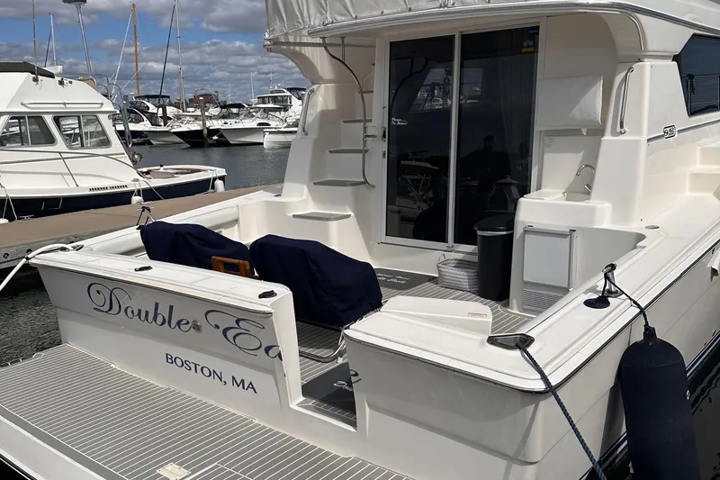 Slide: The Image of 2005 Silverton 42 Convertible yacht docked in Boston marina, featuring spacious deck area. - 4