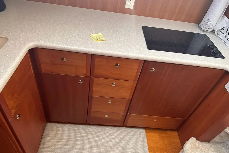 Slide: The Image of 2005 Silverton 42 Convertible yacht kitchen with wooden cabinets and electric stovetop. - 40