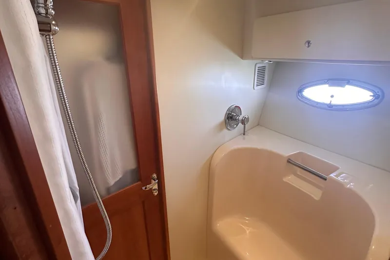 Slide: The Image of 2005 Silverton 42 Convertible yacht bathroom with shower and porthole window. - 45
