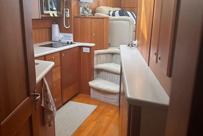 Slide: The Image of Interior of 2005 Silverton 42 Convertible yacht with wooden cabinetry and cozy seating area. - 46