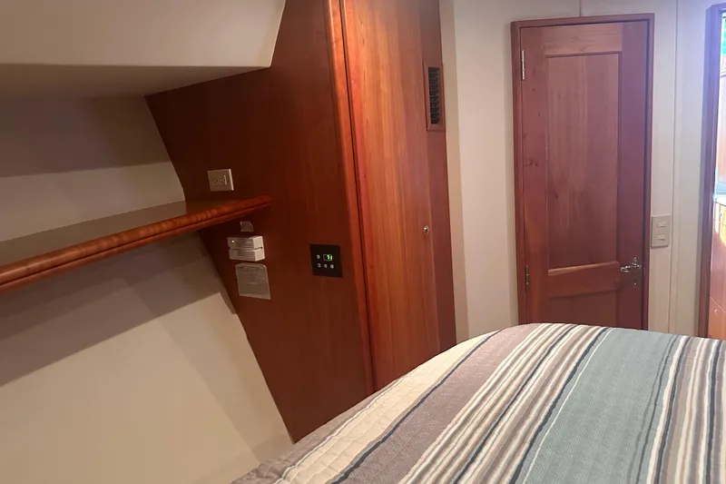 Slide: The Image of Interior of 2005 Silverton 42 Convertible yacht bedroom with wooden door and striped bedding. - 48