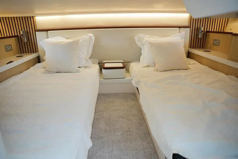 Slide: The Image of Luxurious twin cabin in 2025 Regal LX43 yacht, featuring elegant bedding and modern lighting. - 17