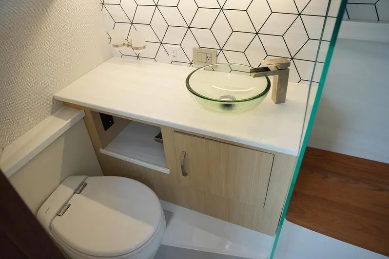 Slide: The Image of Modern bathroom in 2025 Regal LX43 with glass sink and geometric tile design. - 18