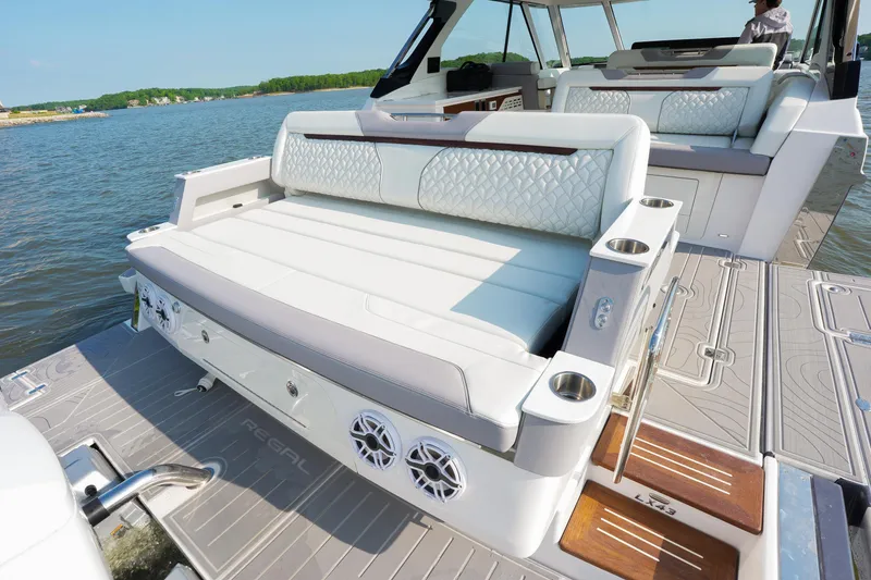 Slide: The Image of Luxurious 2025 Regal LX43 boat interior with plush seating and cup holders on a sunny day. - 5