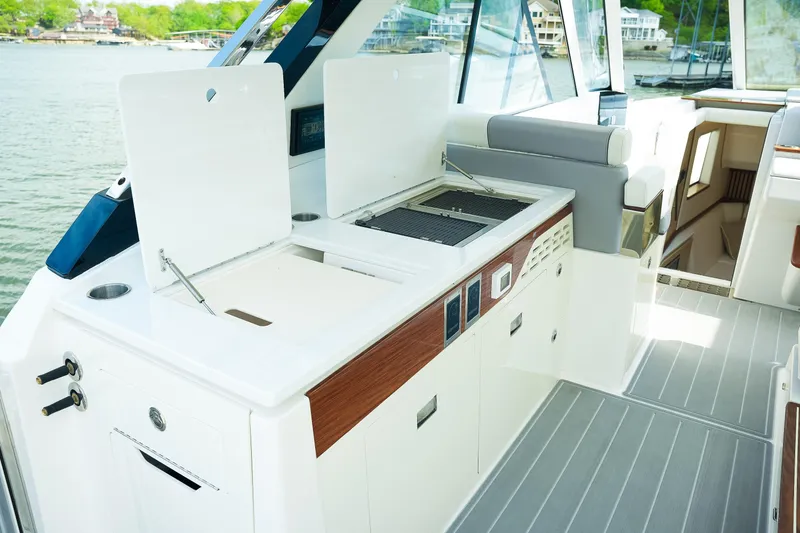 Slide: The Image of 2025 Regal LX43 yacht interior with modern kitchen and seating area by the water. - 8