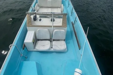 Slide: The Image of 1964 Boston Whaler 17 Montauk boat interior with white seats on calm water. - 12