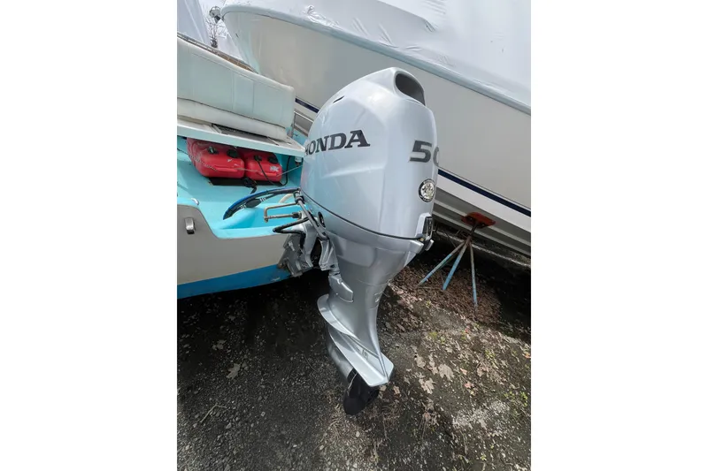 Slide: The Image of 1964 Boston Whaler 17 Montauk with Honda 50 outboard motor, docked outdoors. - 14