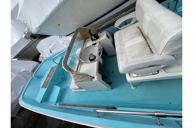 Slide: The Image of 1964 Boston Whaler 17 Montauk boat interior with blue deck and white seating. - 17