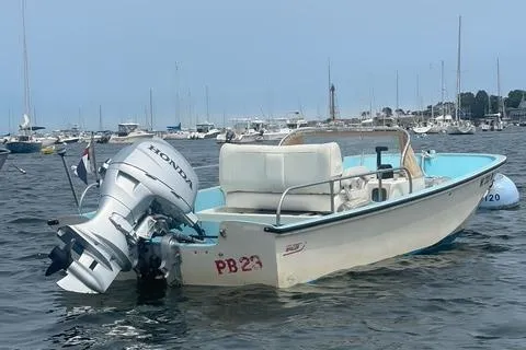 Slide: The Image of 1964 Boston Whaler 17 Montauk boat with Honda outboard motor on water. - 3