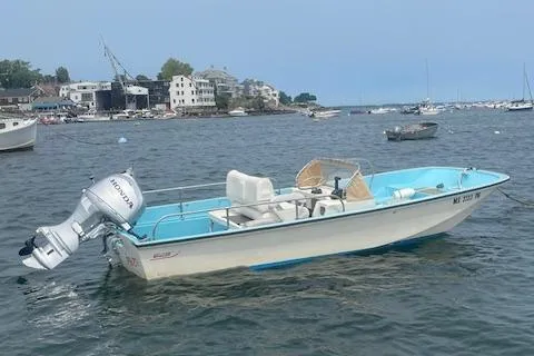 Slide: The Image of 1964 Boston Whaler 17 Montauk boat with Honda outboard motor on calm water. - 4