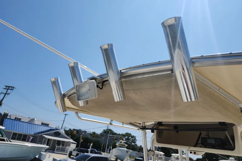Slide: The Image of 2008 Grady-White Fisherman 222 boat with rod holders and canopy under clear blue sky. - 23