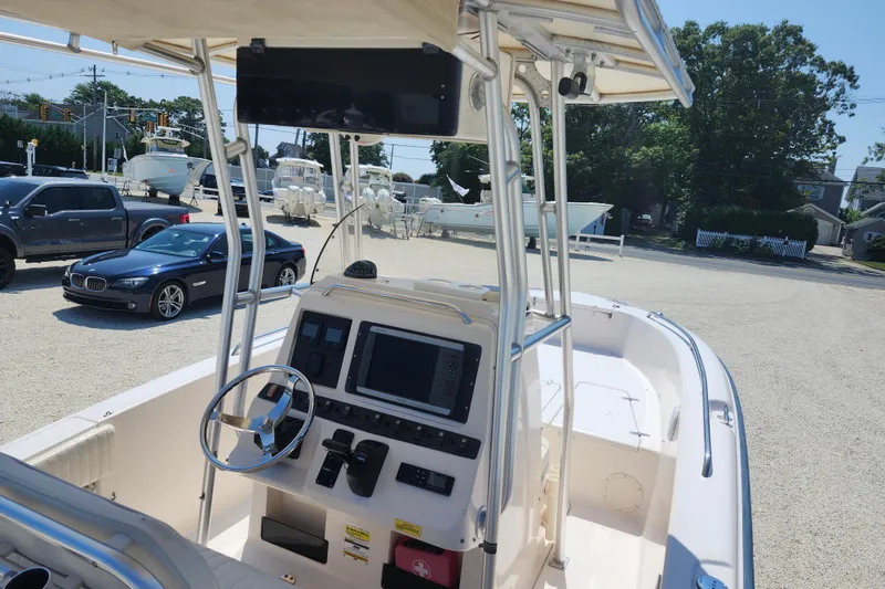 Slide: The Image of 2008 Grady-White Fisherman 222 boat interior with steering console and parked cars in background. - 9