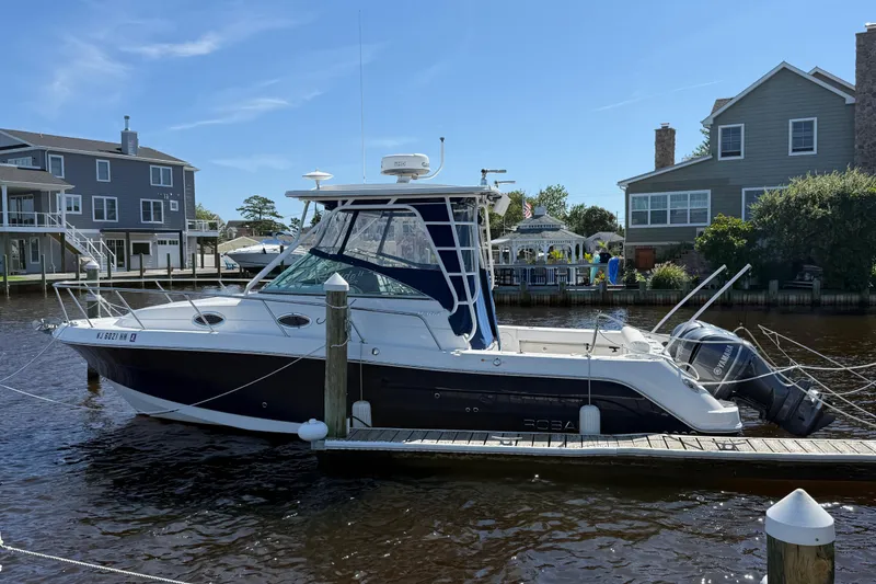 The Image of 2015 Robalo R305 Walkaround boat docked by waterfront homes. - 0