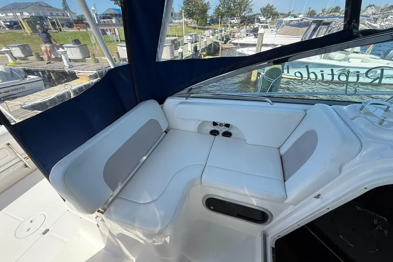 Slide: The Image of 2015 Robalo R305 Walkaround boat interior with white seating and marina view. - 12