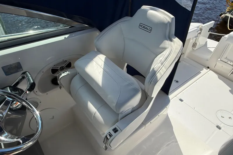 Slide: The Image of 2015 Robalo R305 Walkaround boat interior with white captain's chair and steering wheel. - 13
