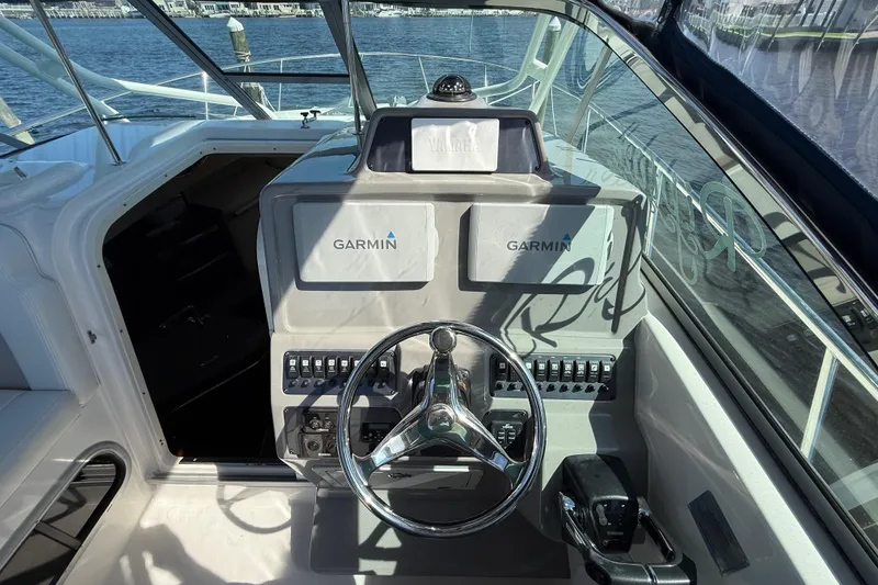 Slide: The Image of 2015 Robalo R305 Walkaround helm with Garmin navigation system, steering wheel, and controls. - 15