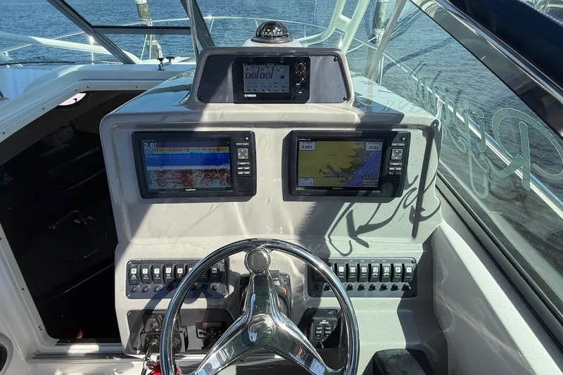 Slide: The Image of 2015 Robalo R305 Walkaround helm with dual navigation screens and steering wheel. - 16