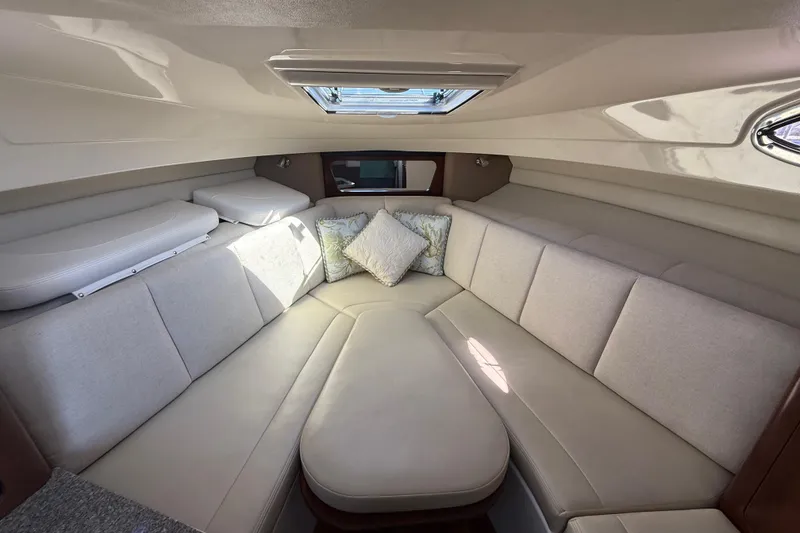 Slide: The Image of 2015 Robalo R305 Walkaround cabin interior with beige seating and decorative pillows. - 20