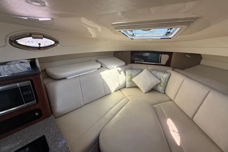 Slide: The Image of 2015 Robalo R305 Walkaround cabin interior with beige seating and decorative pillows. - 21