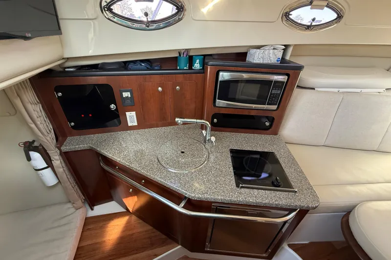 Slide: The Image of Compact kitchen area in 2015 Robalo R305 Walkaround boat with microwave and sink. - 23