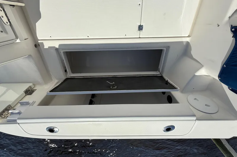 Slide: The Image of 2015 Robalo R305 Walkaround boat storage compartment with open hatch, showcasing interior space. - 26
