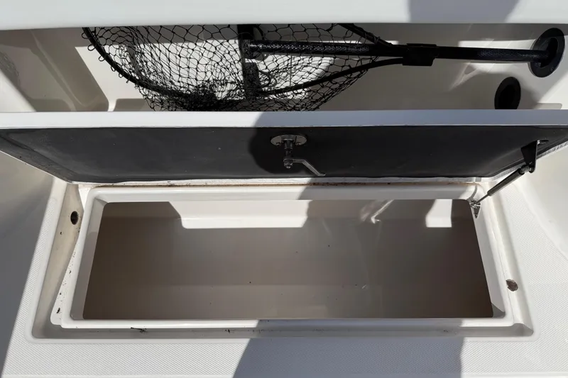Slide: The Image of Open storage compartment on 2015 Robalo R305 Walkaround boat with fishing net. - 28