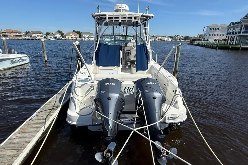 Slide: The Image of 2015 Robalo R305 Walkaround boat docked with twin 300 horsepower engines. - 3